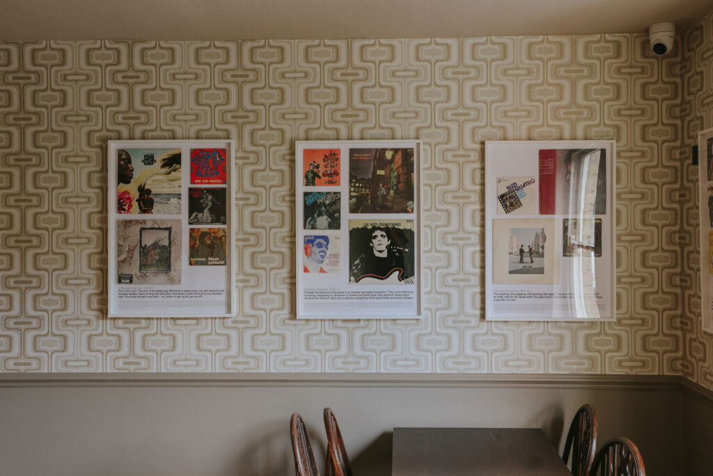 70s interior with funky wallpaper and poster frames on the wall